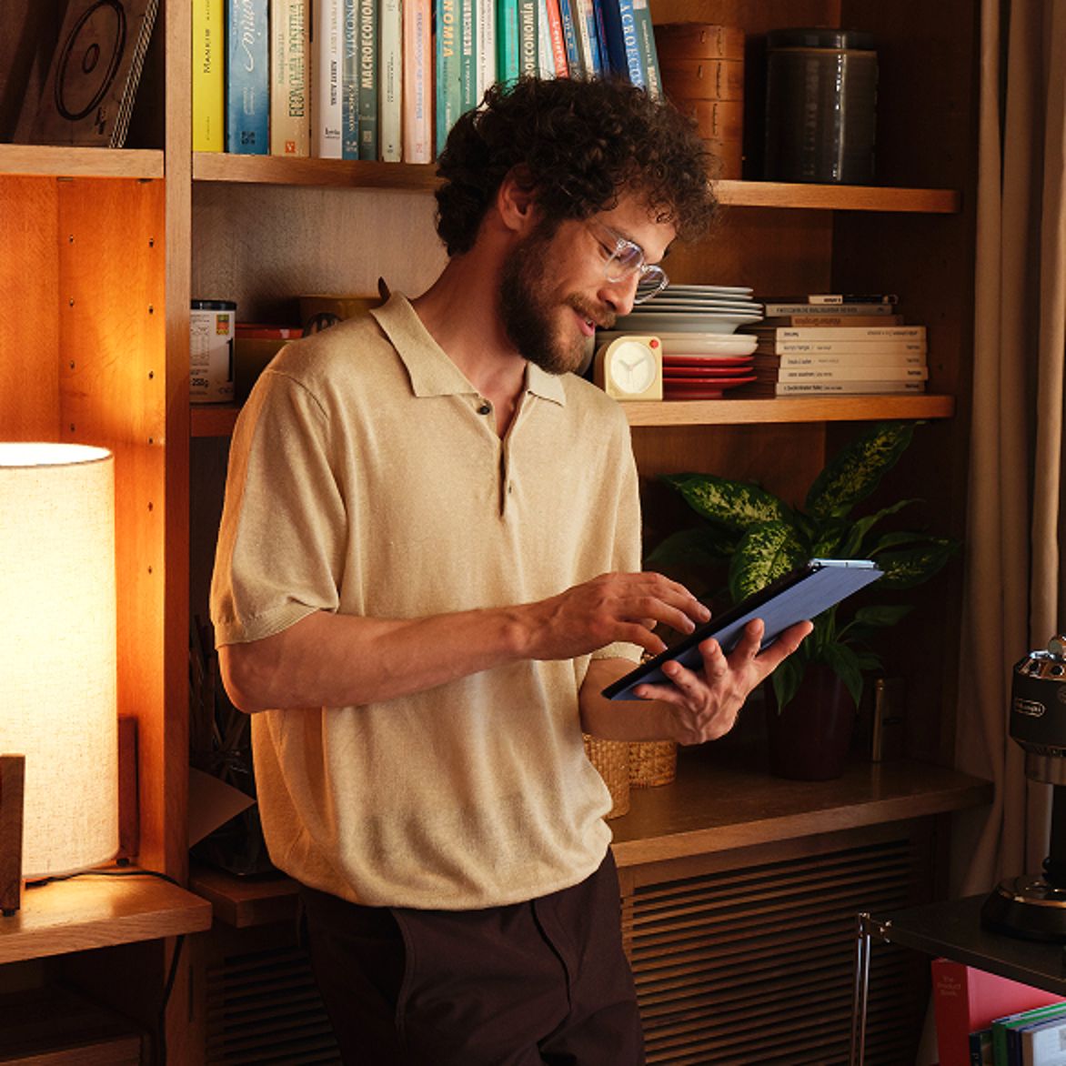Person using tablet beside bookshelf, representing AI-powered audience targeting and insights.