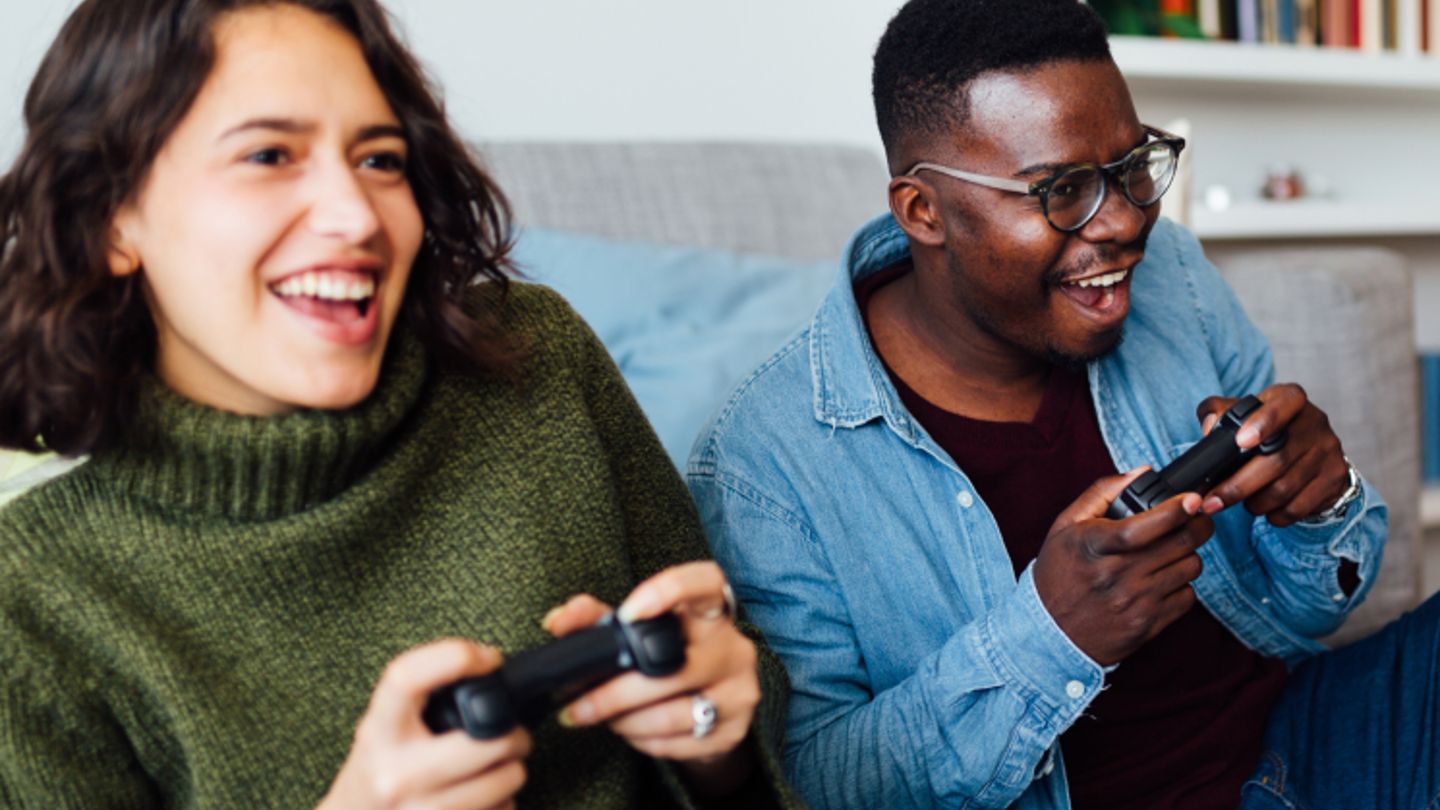 Man and woman playing video games on a couch