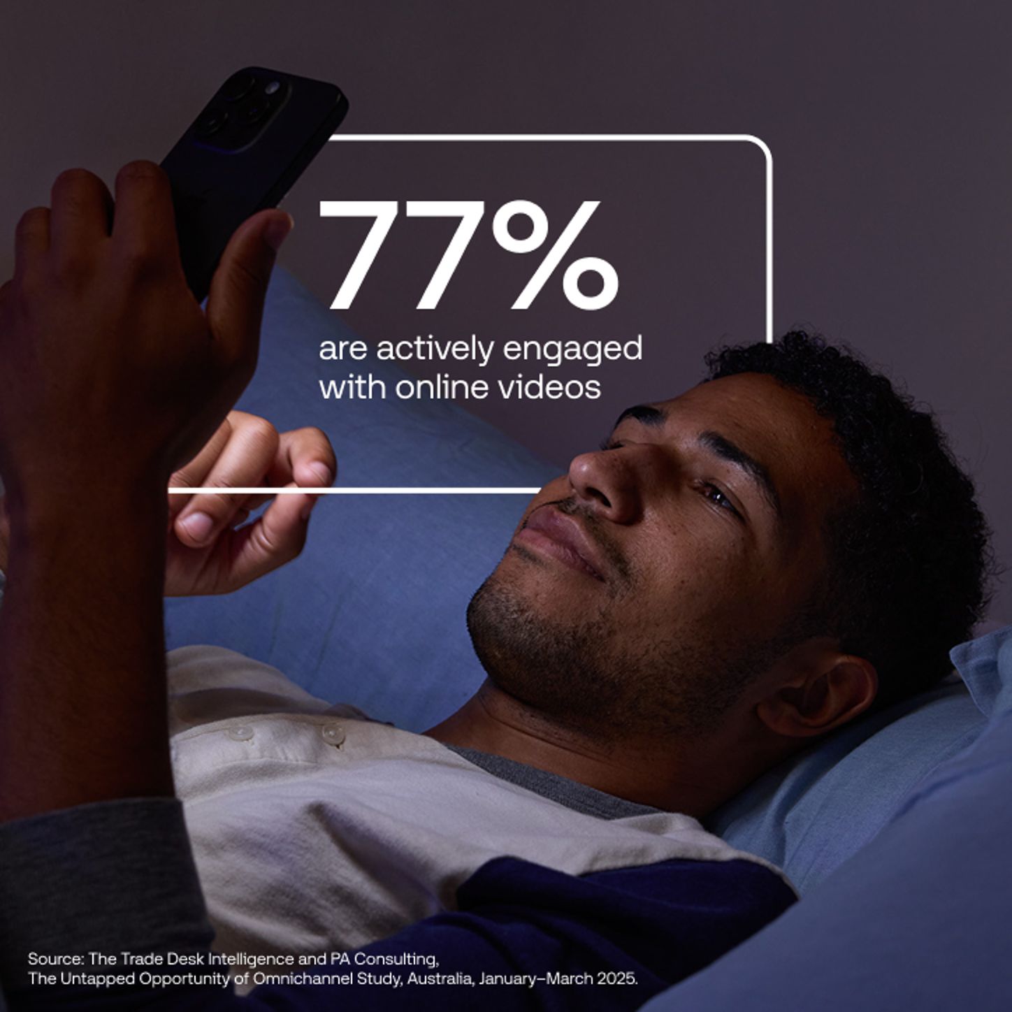 Man lying in bed, looking at mobile phone.