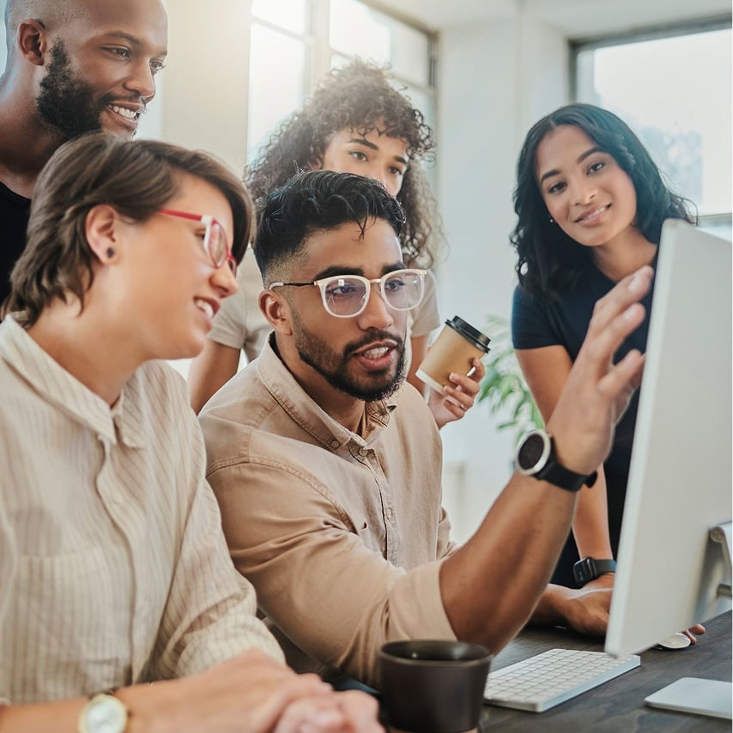 Coworkers all surrounding a computer