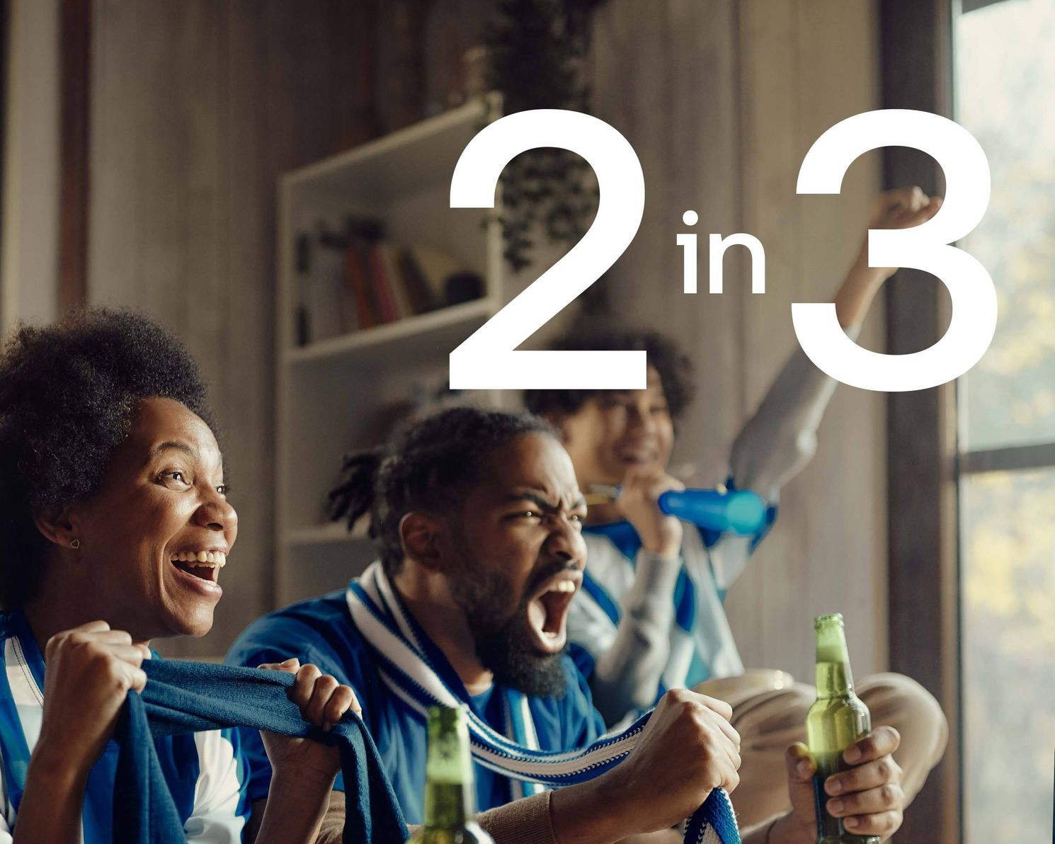 Fans cheering on a sports game with beverages in their hands and a 2 in 3 in white text overlaid on the image.