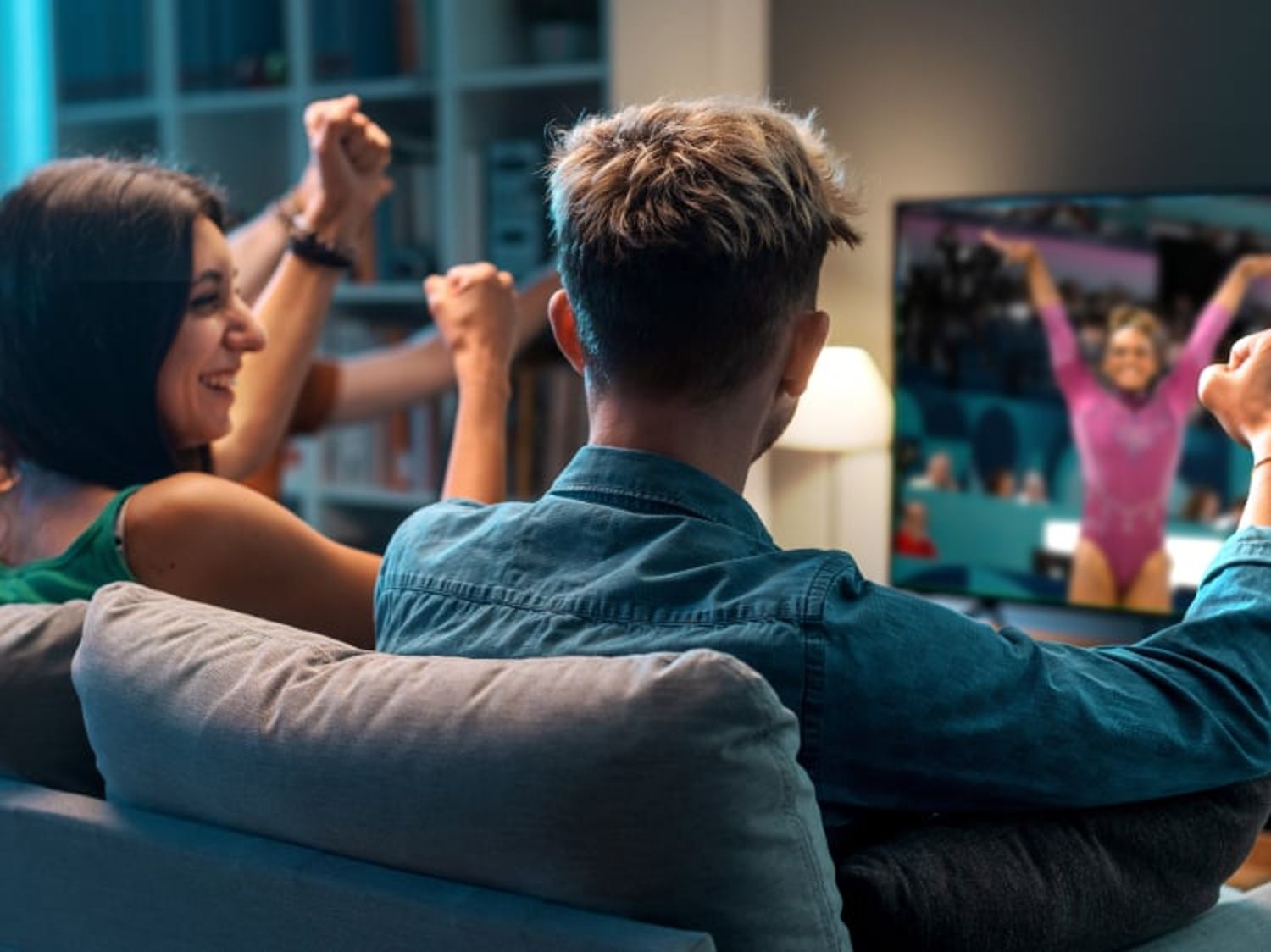 Group of people watching gymnastics at the Winter Games on their television