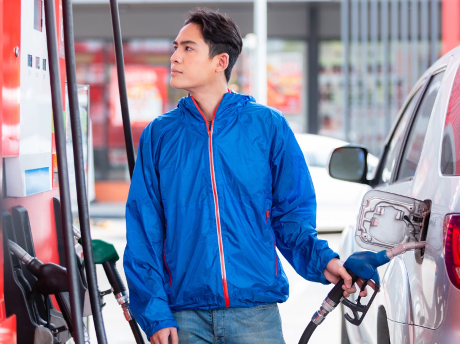 Image of a man pumping gas in his car