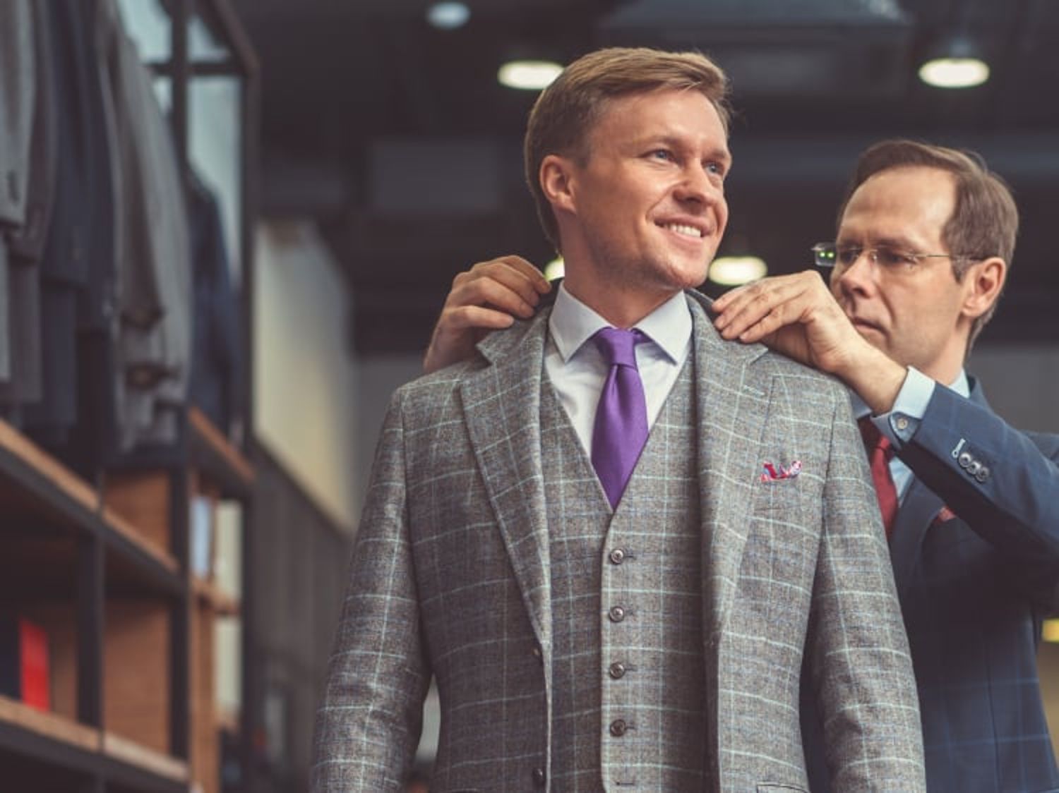 Sales associate adjusting a male in his suit from Men's Wearhouse