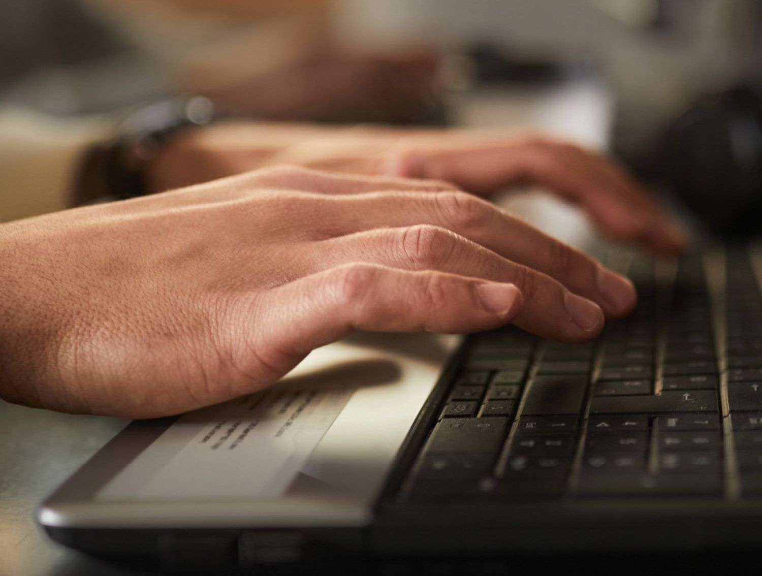 Hands typing on a keyboard