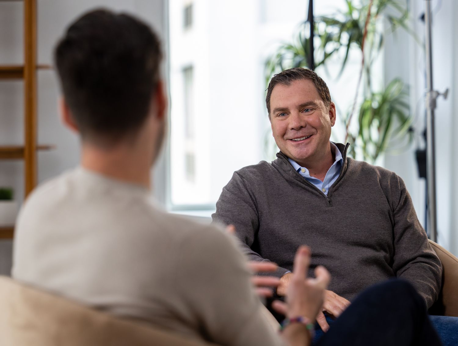 Dave DeRobbio seated in discussion during filmed interview in modern office setting
