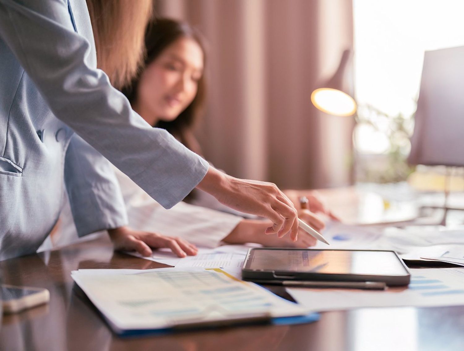 Coworkers looking at a tablet at their desk