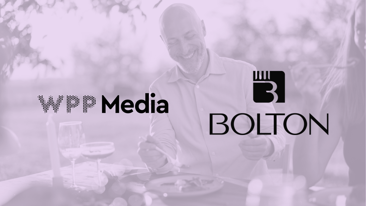 A smiling man sits at a table with the logos for WPP Media and BOLTON overlaid on a soft, purple-tinted background.