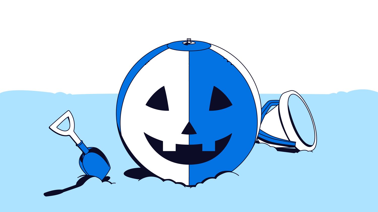 A blue and white beach ball designed as a Halloween pumpkin, partially submerged in sand with a shovel and bucket nearby.