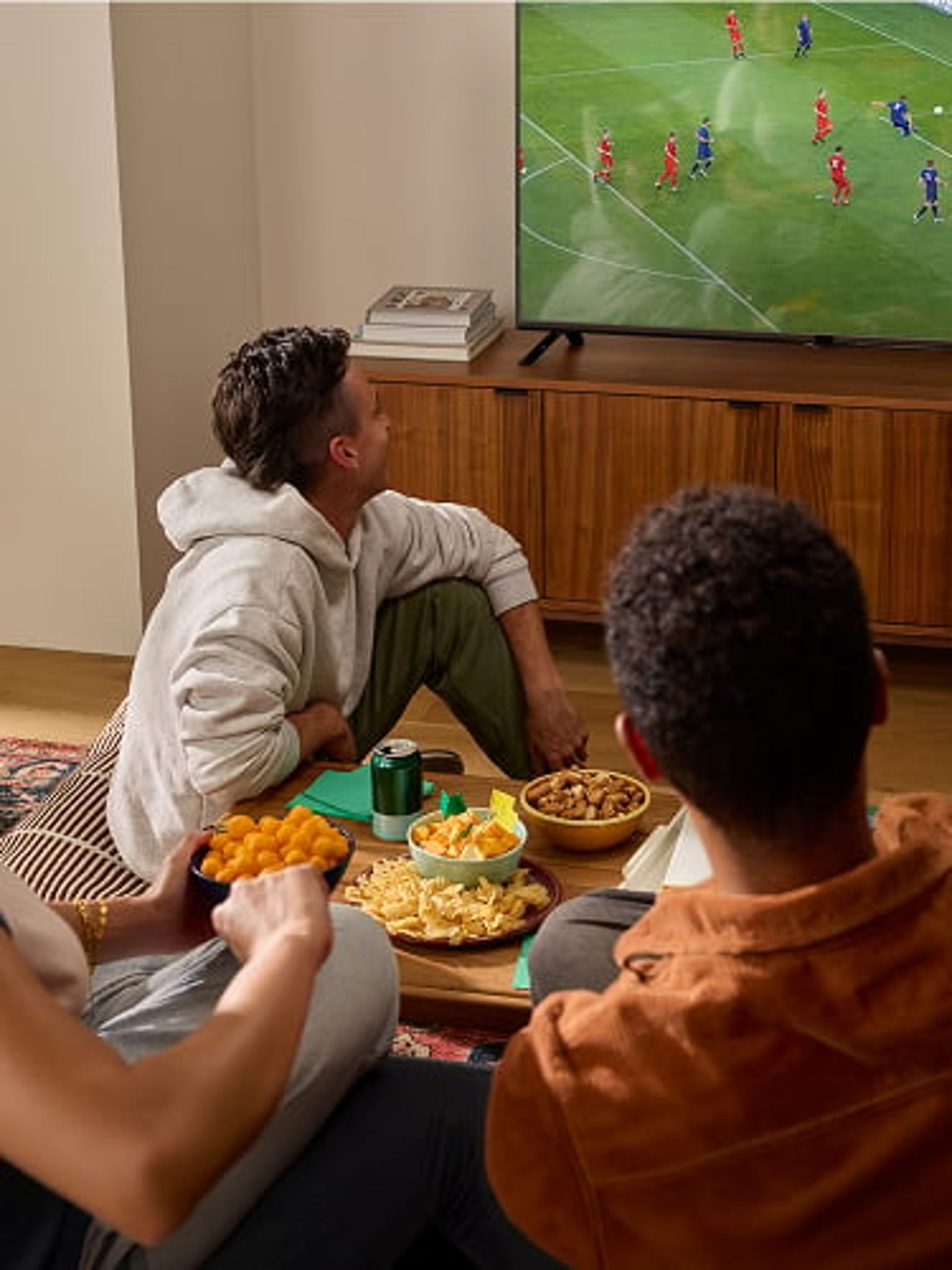 Group of friends watching a sporting event on television