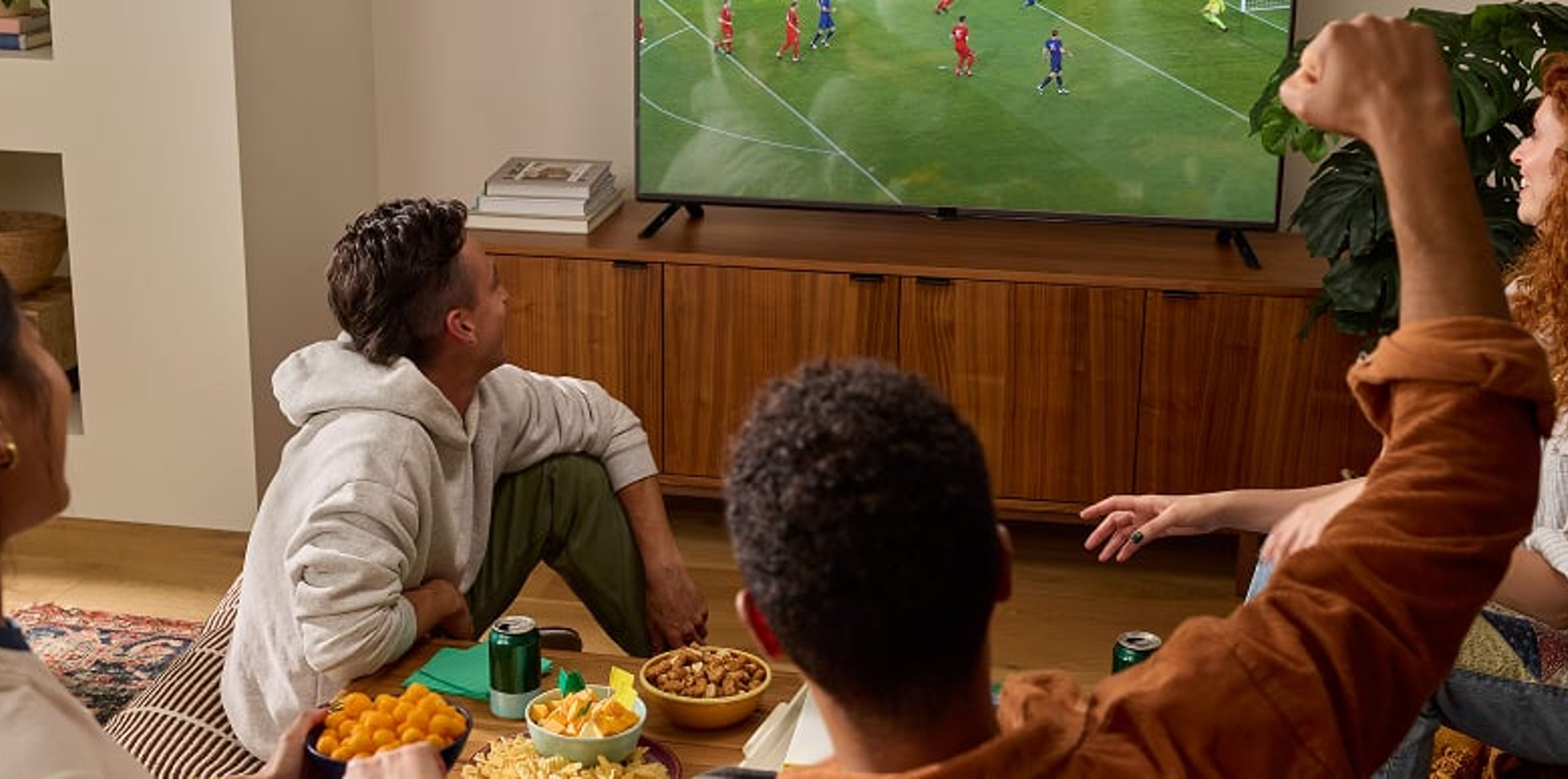 Group of friends watching a sporting event on television