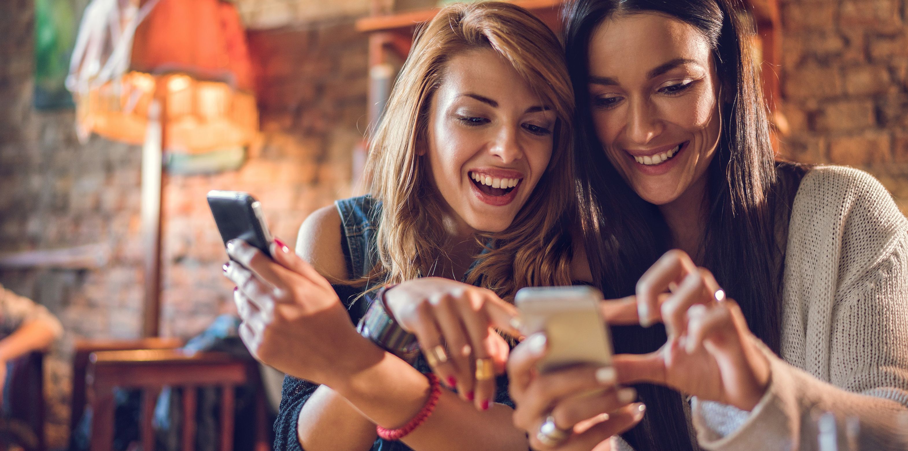 2 women at a restaurant looking at a phone
