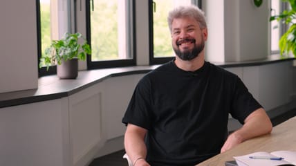 Foto von Christian Busch, Product Lead bei MINT Square, der in die Kamera lächelt.