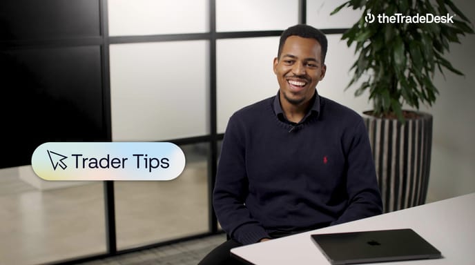 Man smiling in an office setting with a laptop on the desk, overlaid text reading "Trader Tips," and The Trade Desk logo in the top right corner.