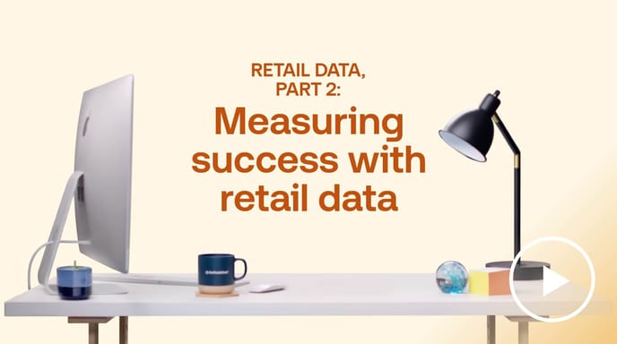 Desk with computer and lamp beside ‘Measuring success with retail data’ text by The Trade Desk, illustrating retail data analytics.