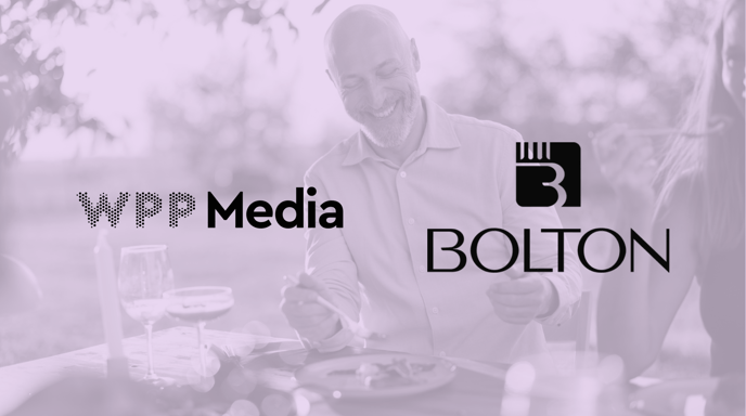 A smiling man sits at a table with the logos for WPP Media and BOLTON overlaid on a soft, purple-tinted background.