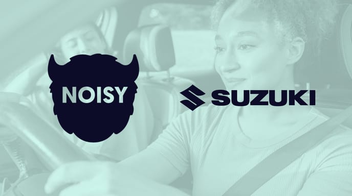 Green image of two people driving in a car with Noisy and Suzuki logos over