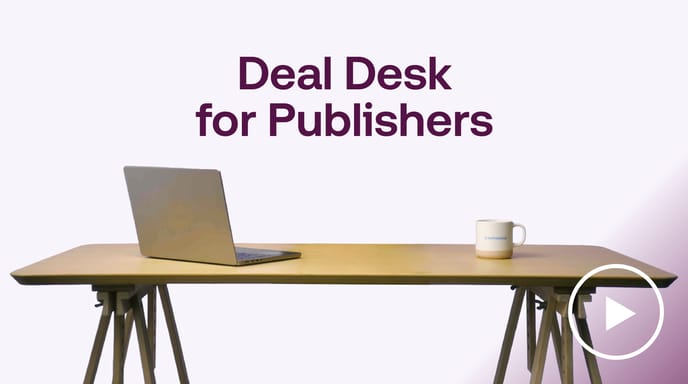 Laptop and coffee mug on a desk with the headline “Deal Desk for Publishers” displayed above on a clean studio background.