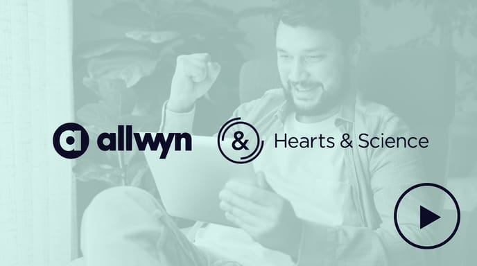 A man sitting in a chair looks excited and celebrates with a fist pump while using a tablet.