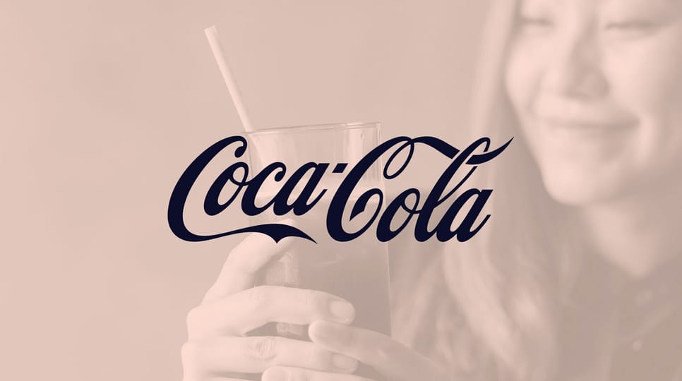 A woman smiles while holding a glass of cola with a paper straw, overlaid with the Coca-Cola logo.