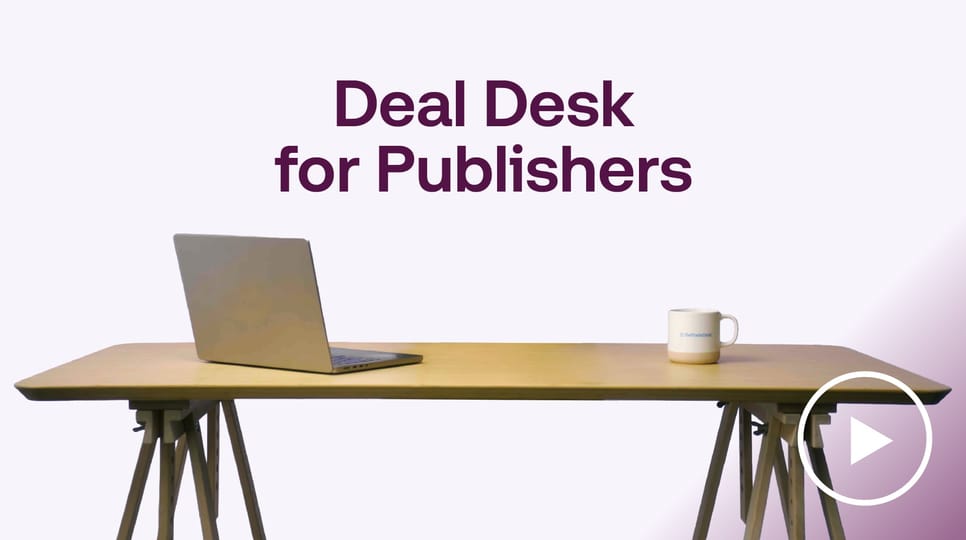 Laptop and coffee mug on a desk with the headline “Deal Desk for Publishers” displayed above on a clean studio background.