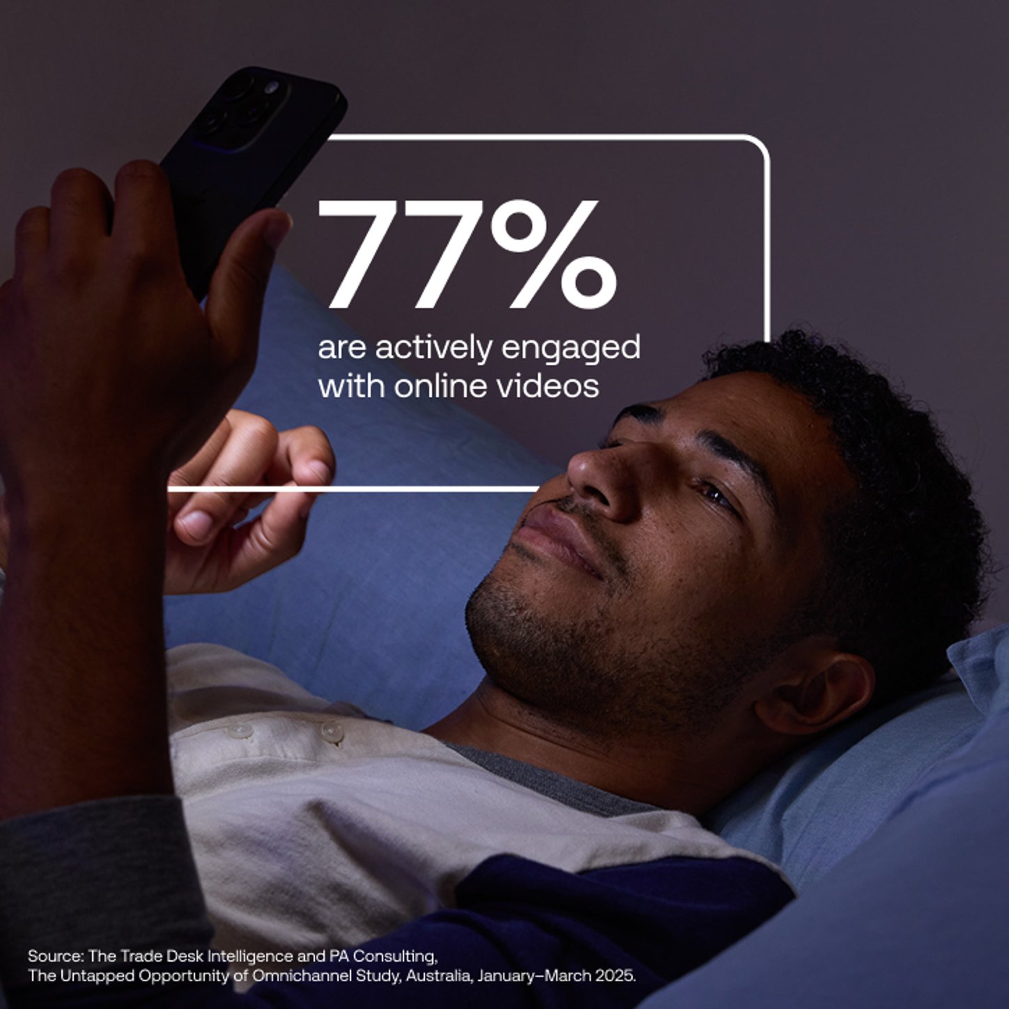 Man lying in bed, looking at mobile phone.