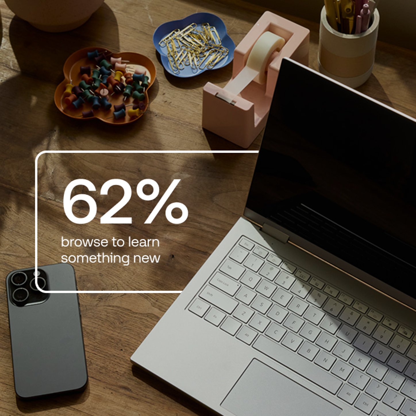 A statistic stating “62% browse to learn something new” is overlaid on a top-down image of a wooden desk with a laptop, smartphone, and office supplies.