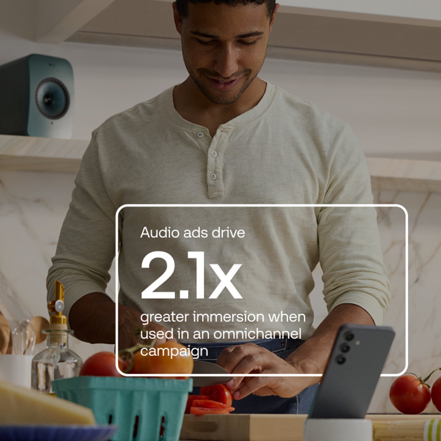 A statistic reading “Audio ads drive 2.1x greater immersion when used in an omnichannel campaign” is displayed over an image of a man chopping vegetables in a kitchen with a smartphone and speaker nearby.