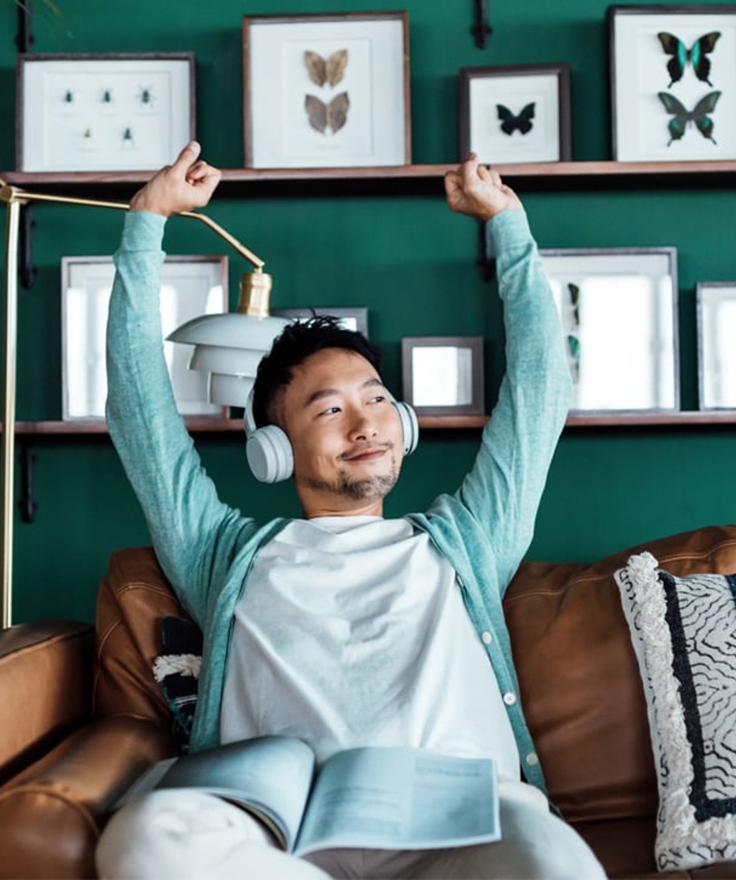 Man wearing headphones stretching his arms upwards