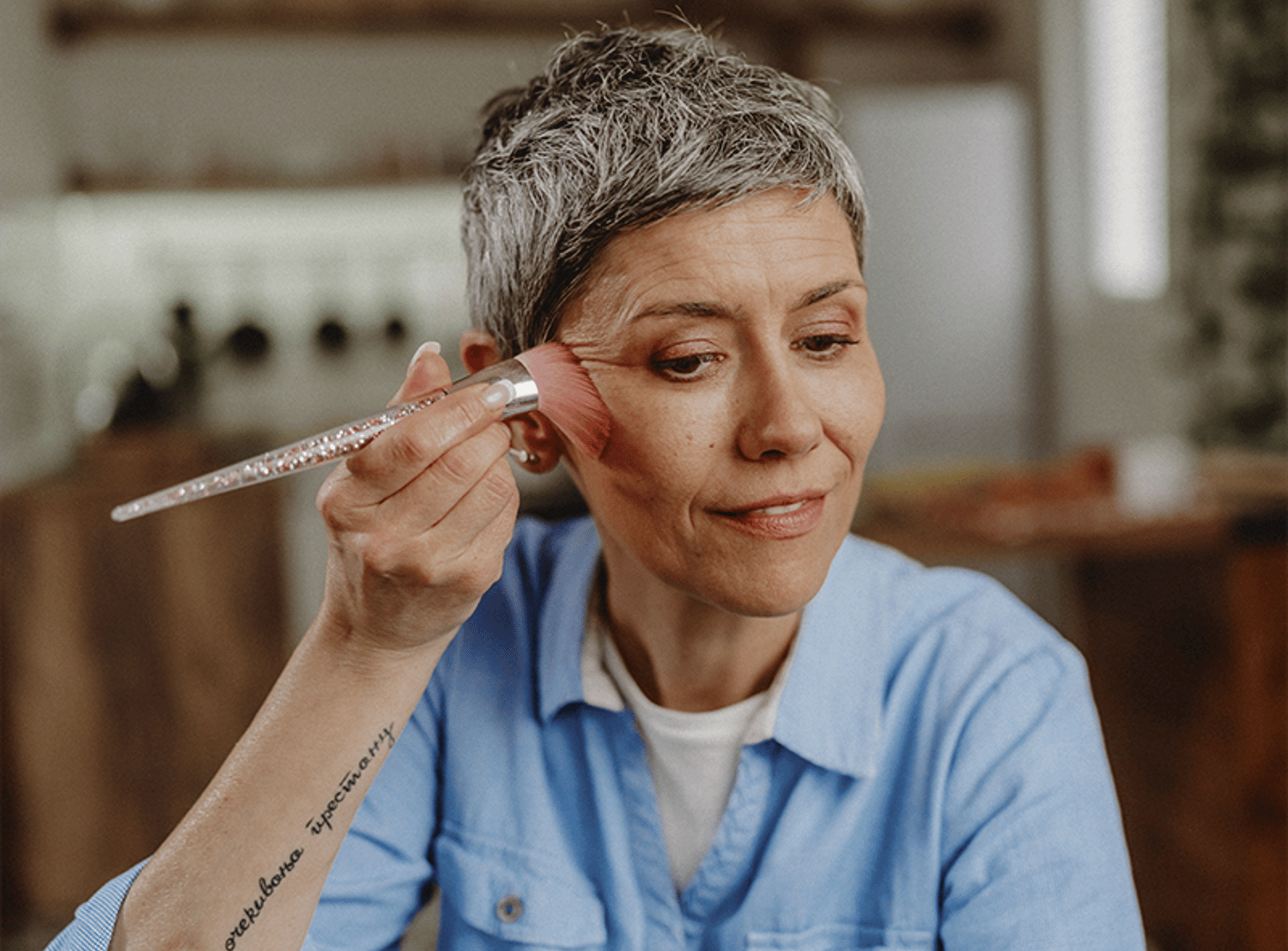 Image of a woman applying makeup with a brush