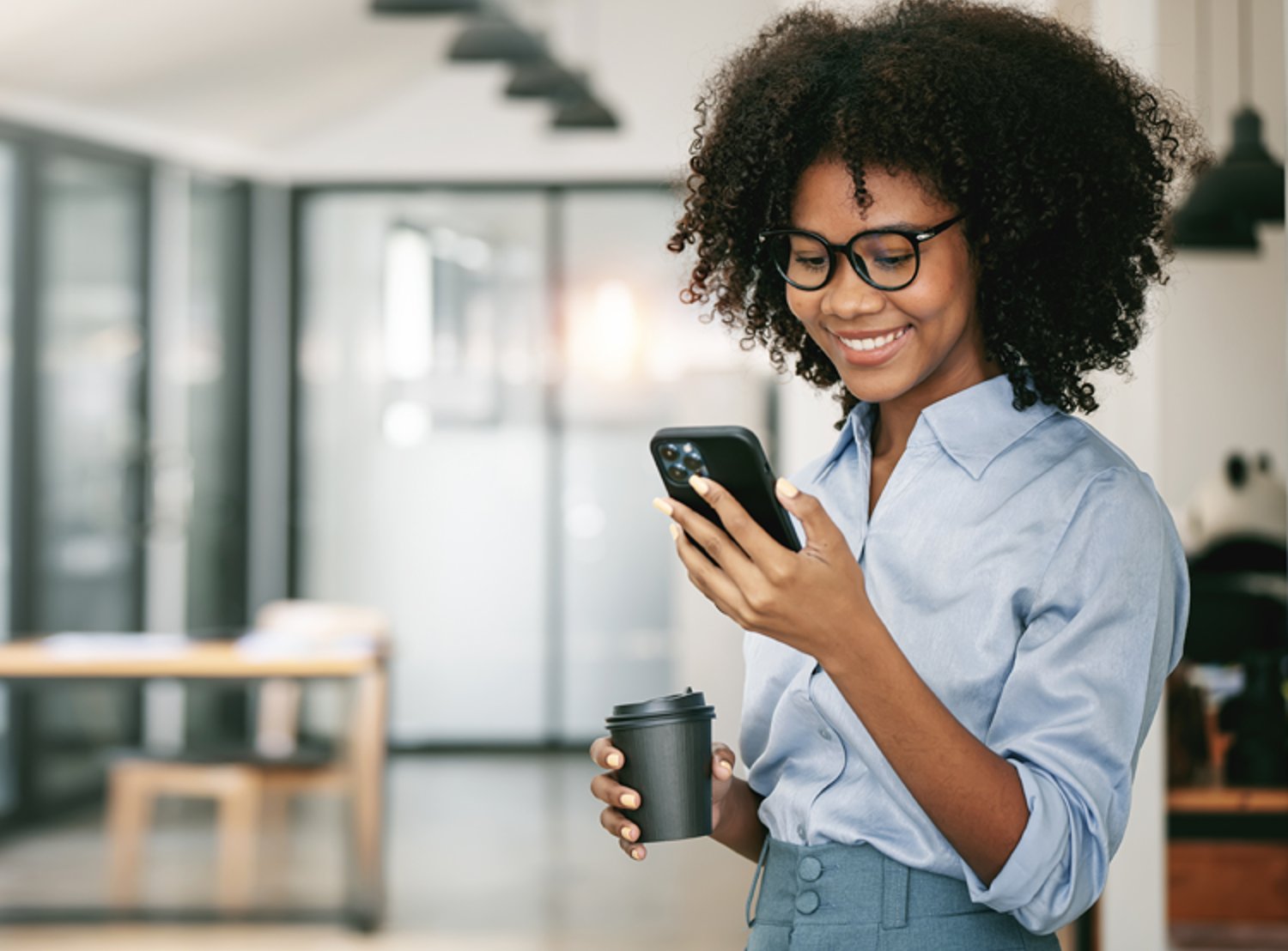 Picture shows a person busy on their phone while a holding cup of coffee. Goodway Group logo sits at the top right corner