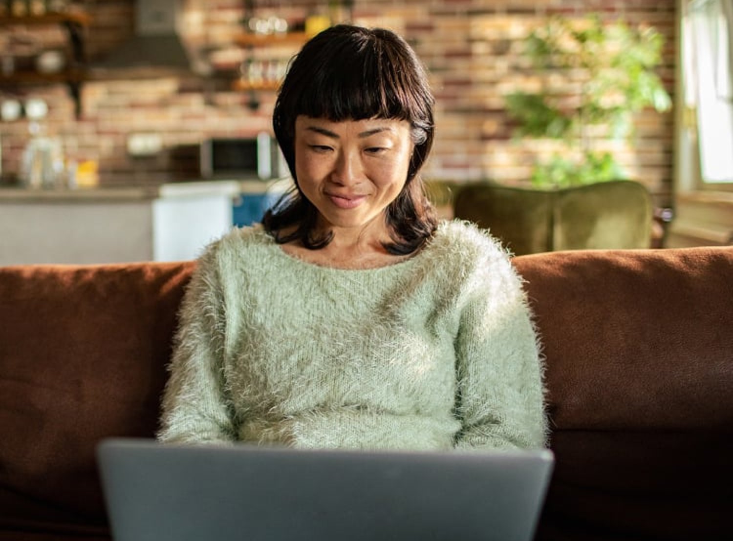 Woman smiling and looking at a laptop