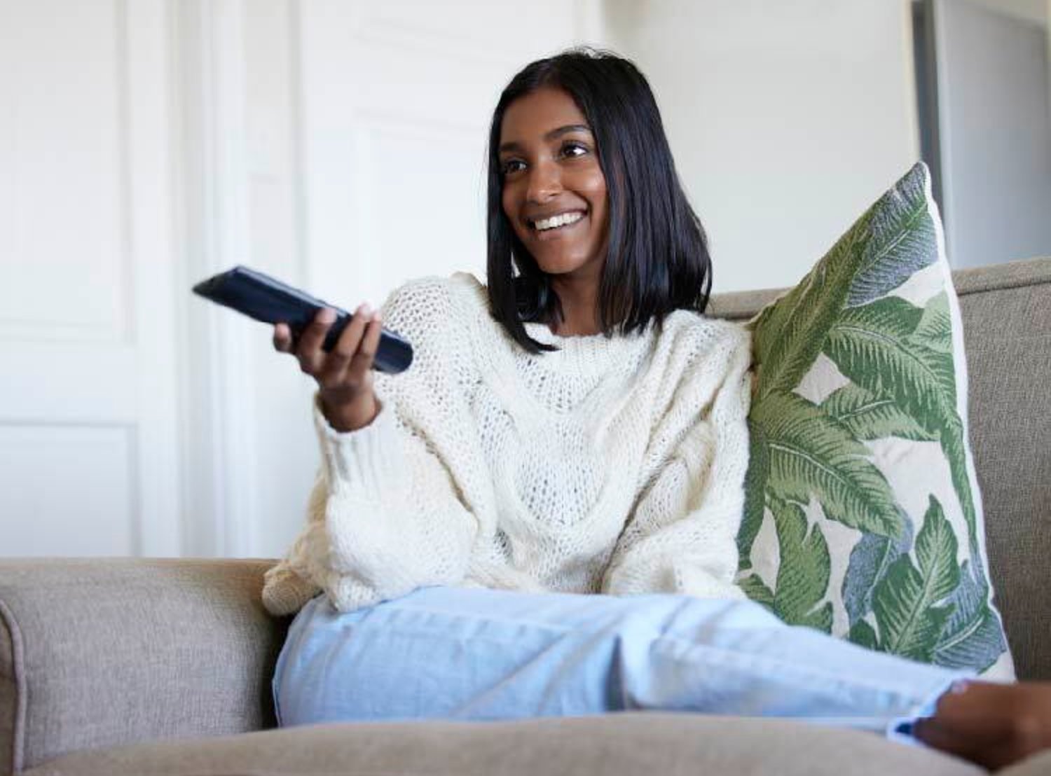 Woman watching TV and using her remote