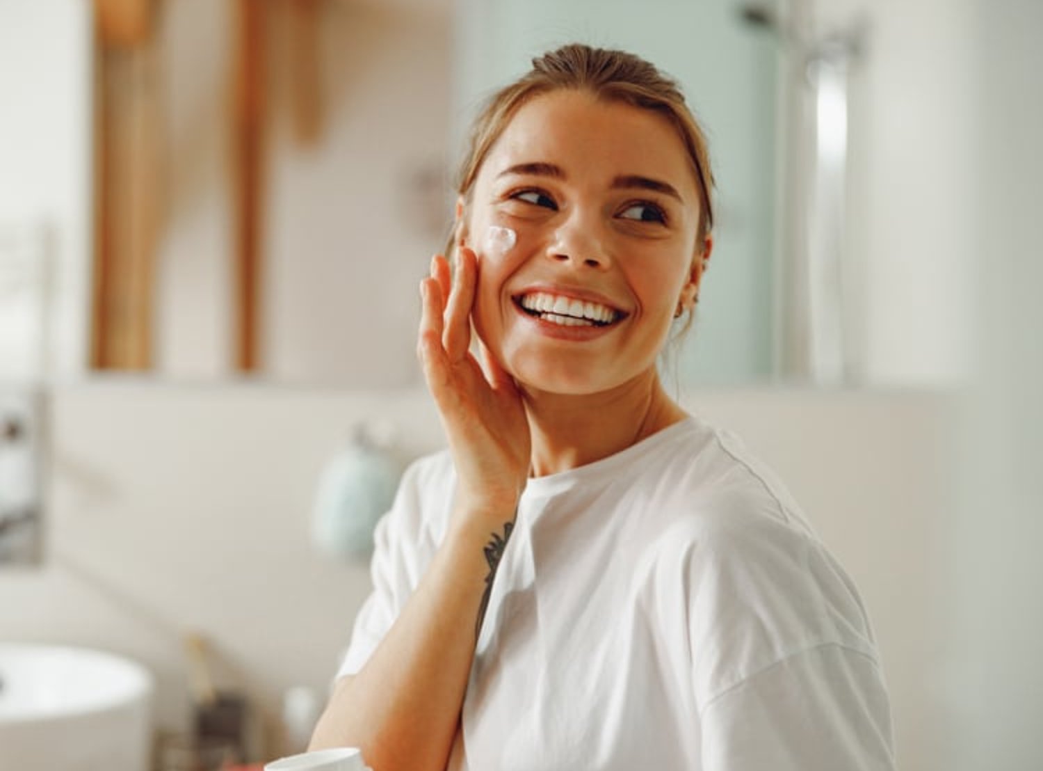 A woman applies Neutrogena cream to her face