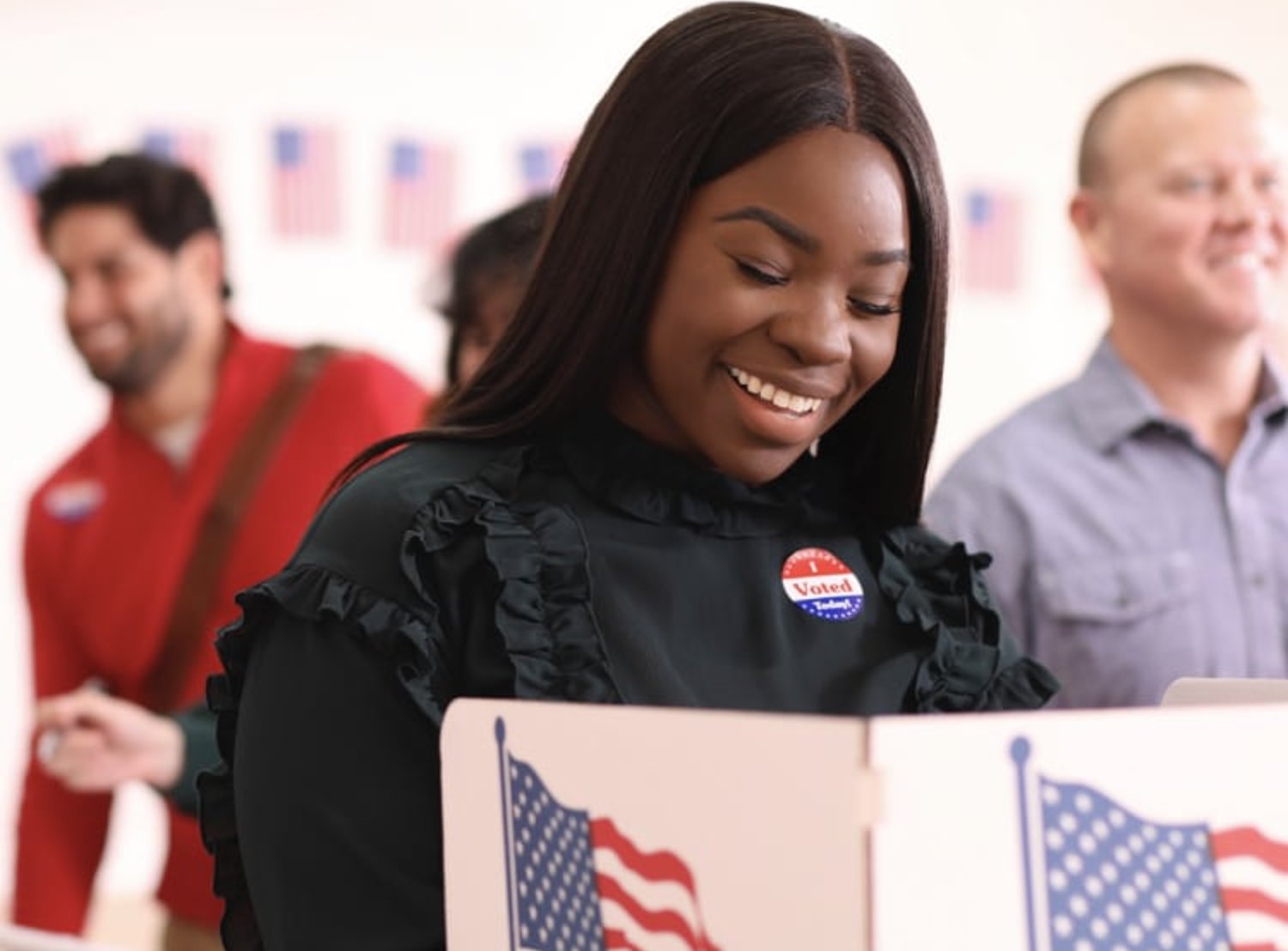 Woman smiling and voting at a polling booth