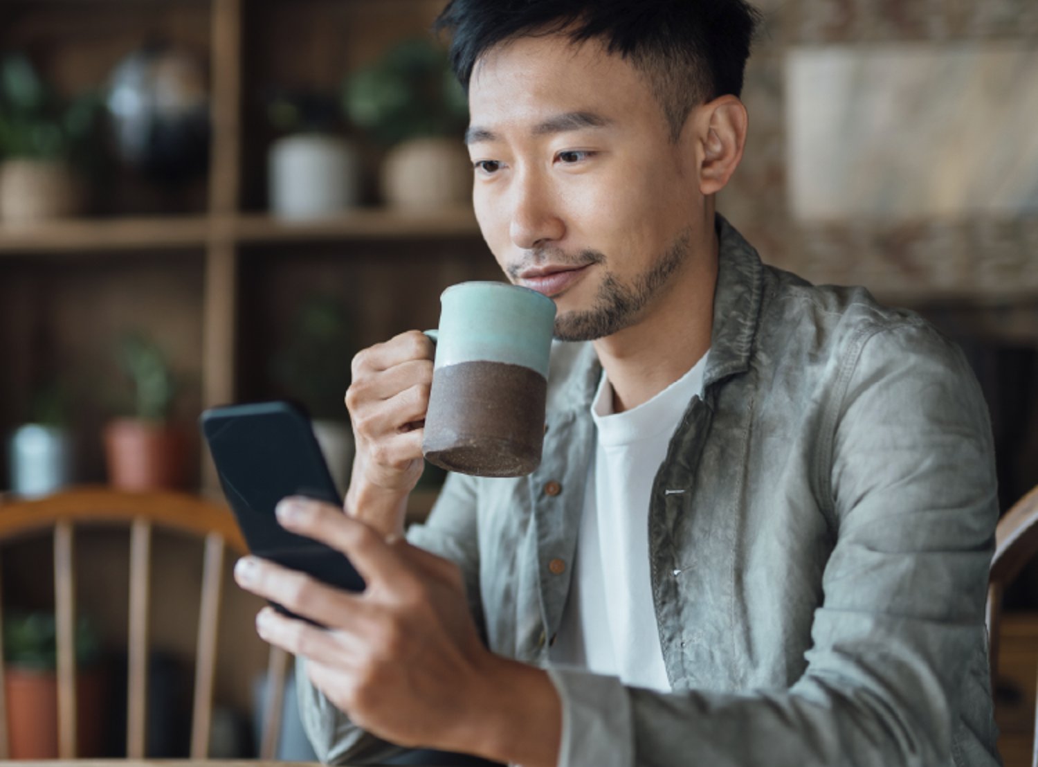 Man on his phone and drinking coffee