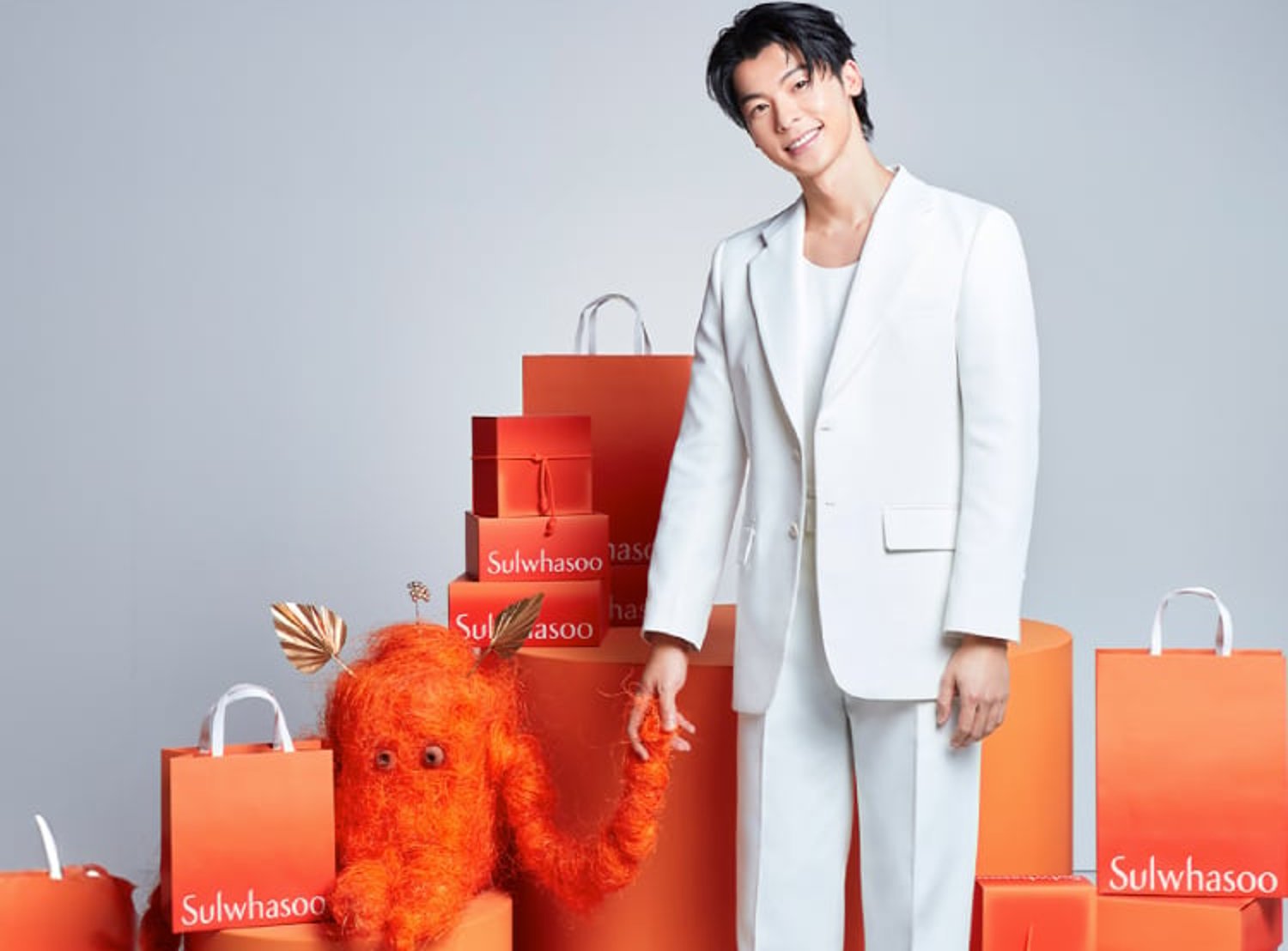 Sulhwasoo campaign image of a man standing in front of orange shopping bags