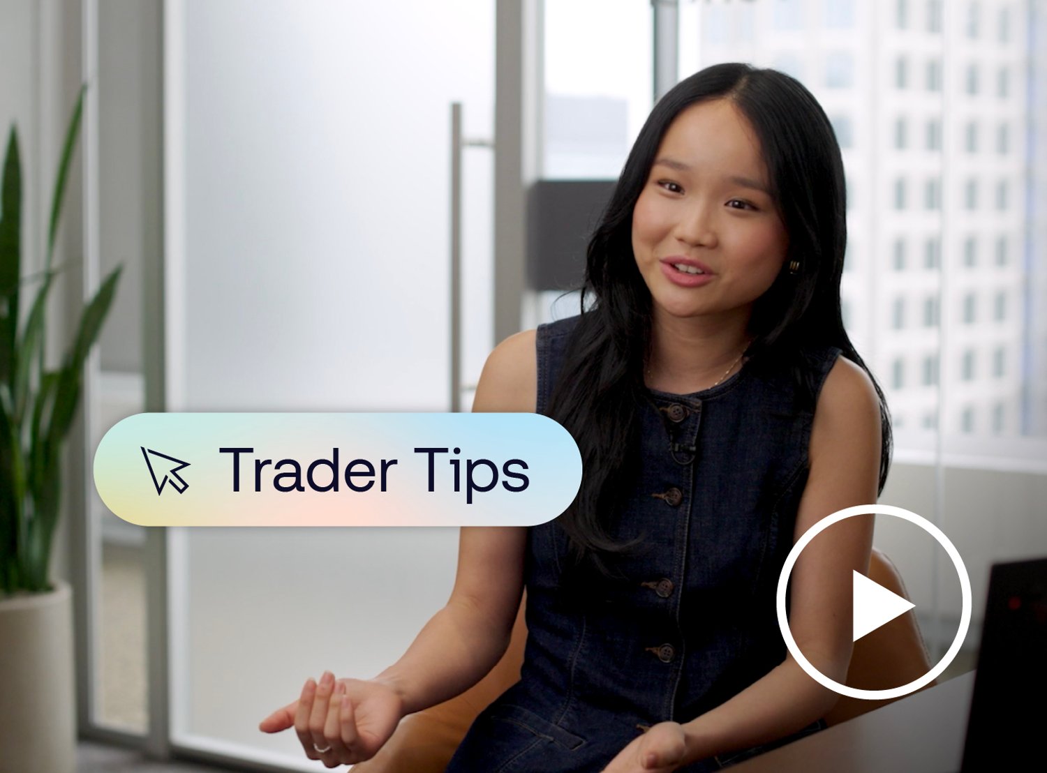 Woman sitting at a desk with a graphic of text saying "Trader Tips" and a play button placed over her