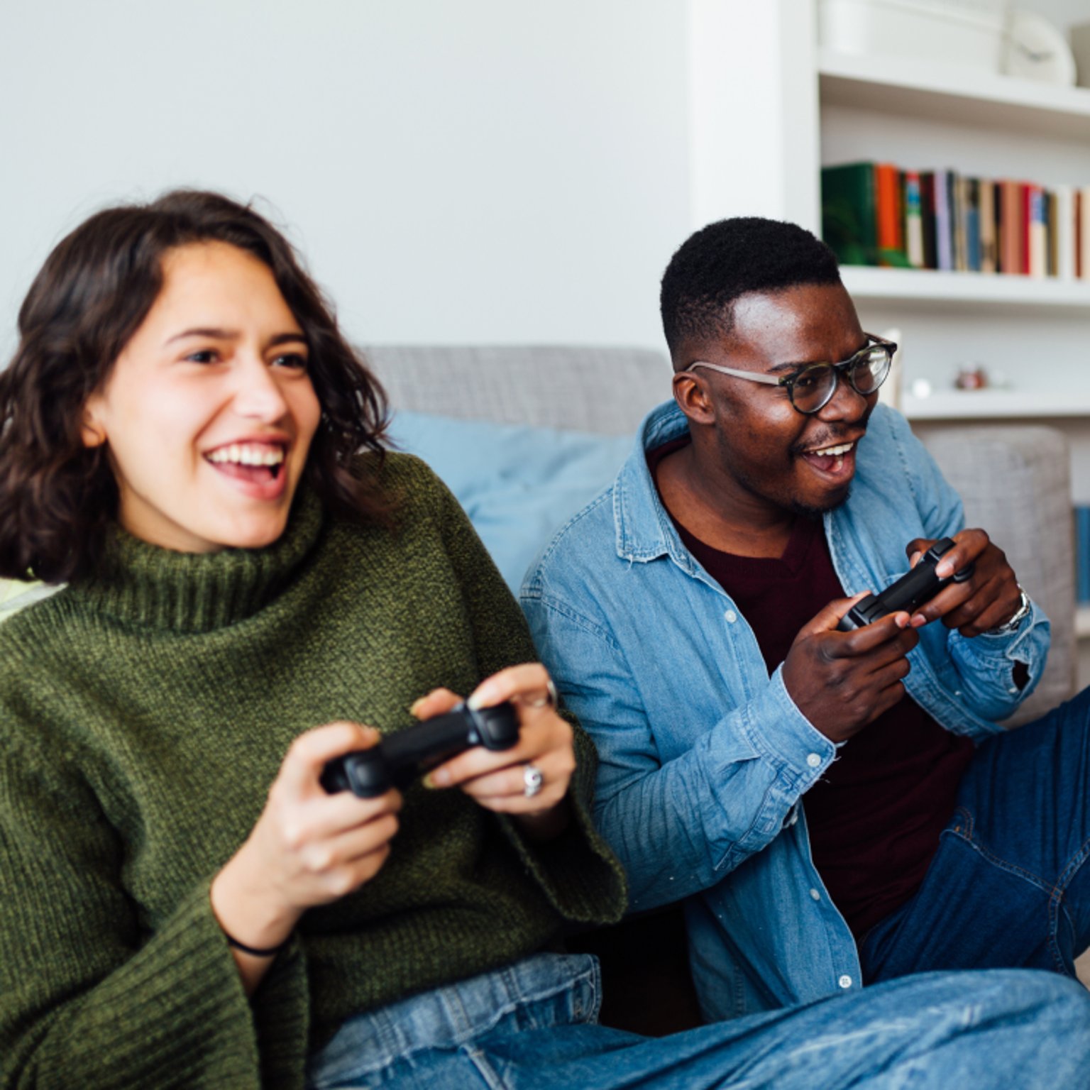 Man and woman playing video games on a couch