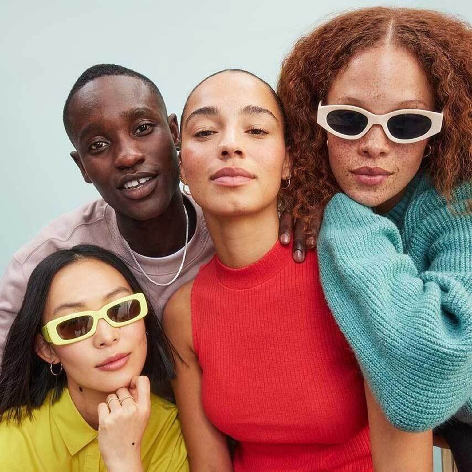 Stylish group of diverse friends posing confidently in colorful outfits and trendy sunglasses