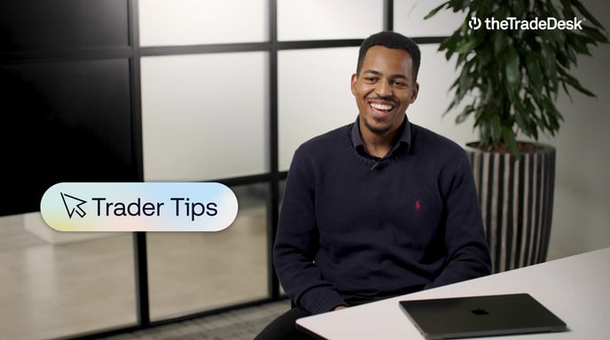Man smiling in an office setting with a laptop on the desk, overlaid text reading "Trader Tips," and The Trade Desk logo in the top right corner.
