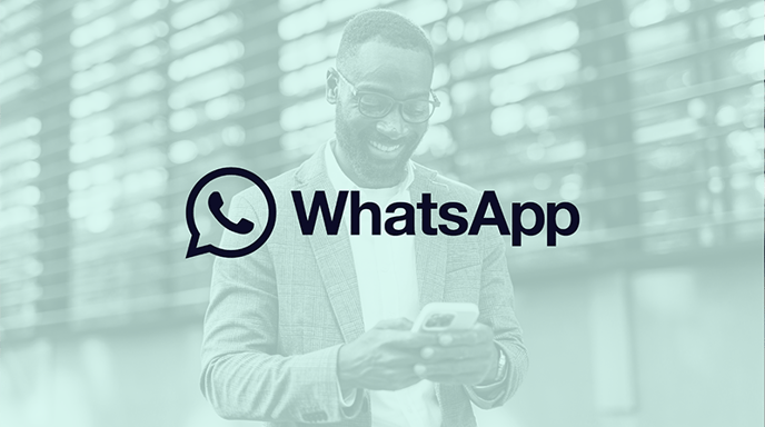 Image of a man smiling at his phone with a green filter over and the WhatsApp logo in the center