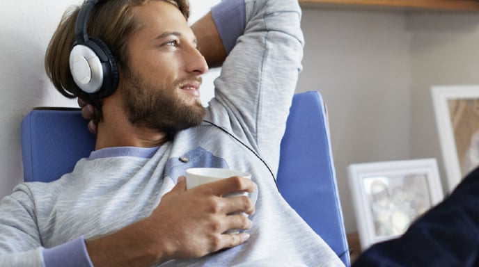 Man listening to headphones and staring off into the distance