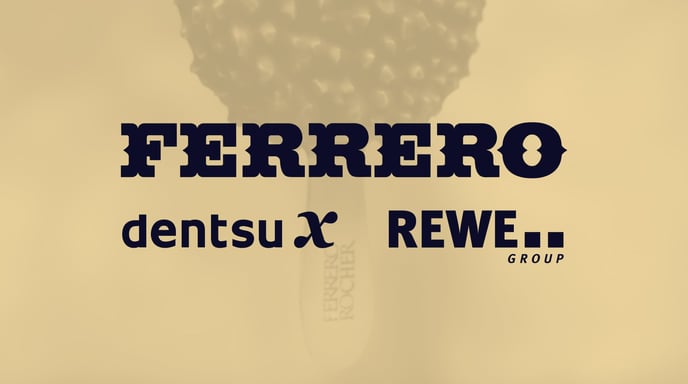 Image shows a Ferrero Rocher ice cream bar. Ferrero Rocher, Dentsu X, Rewe Group logos are pictured in the top left corner of the image