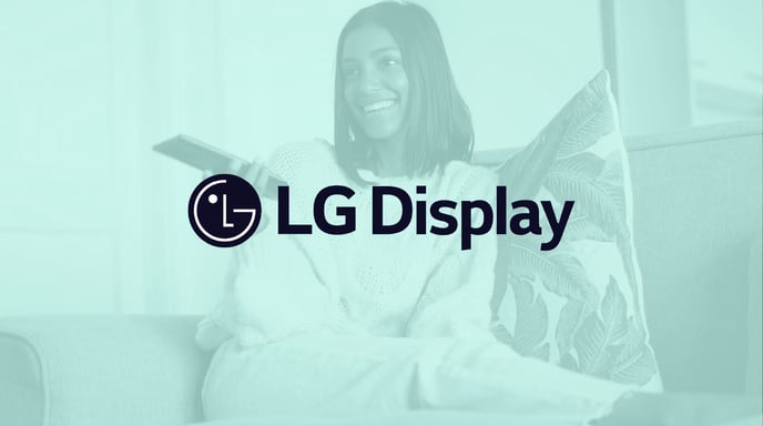 Woman watching TV and using her remote with a green tint and the LG Display logo in the center