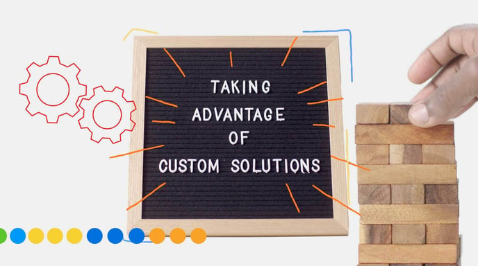 A letter board reads "Taking advantage of custom solutions" while a hand builds a tower on the right hand side.