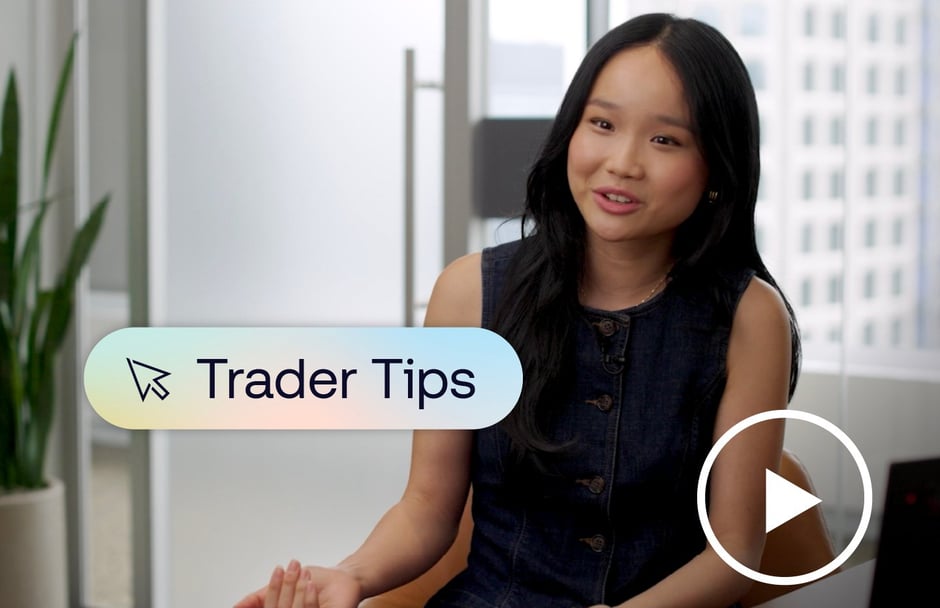 Woman sitting at a desk with a graphic of text saying "Trader Tips" and a play button placed over her