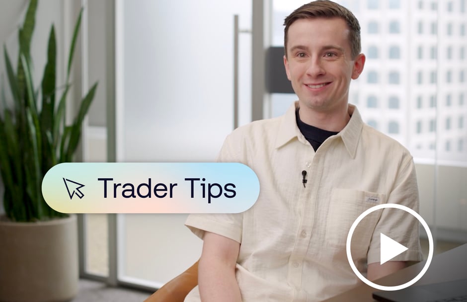 Man sitting at a desk with a graphic of text saying "Trader Tips" and a play button placed over him