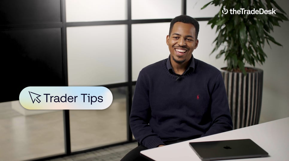 Man smiling in an office setting with a laptop on the desk, overlaid text reading "Trader Tips," and The Trade Desk logo in the top right corner.