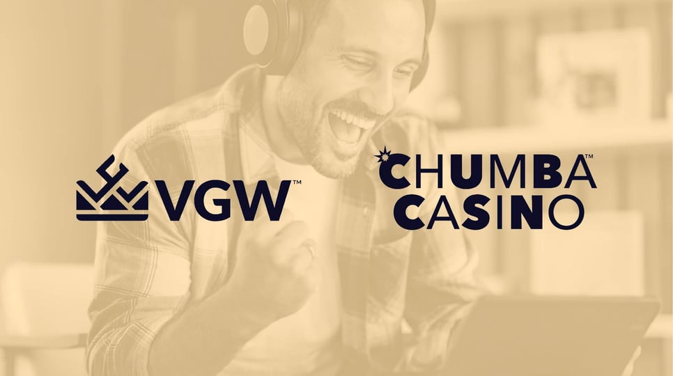 Man cheering while looking at a laptop and wearing headphones with a yellow cover and logos for Chumba Casino and Virtual Gaming Worlds